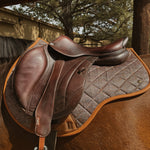 performance saddle pad, under saddle, in herringbone pattern with cognac trim. 