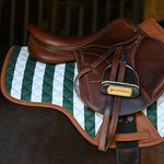 Brown leather saddle on a striped green and white saddle pad. Sixteen Cypress.